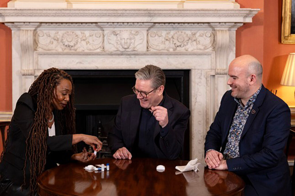 Sir Keir Starmer, singer Beverley Knight, and THT CEO Richard Angel sit in front of a fireplace in Downing Street - as Sir Keir Starmer takes a HIV test for HIV Testing Week